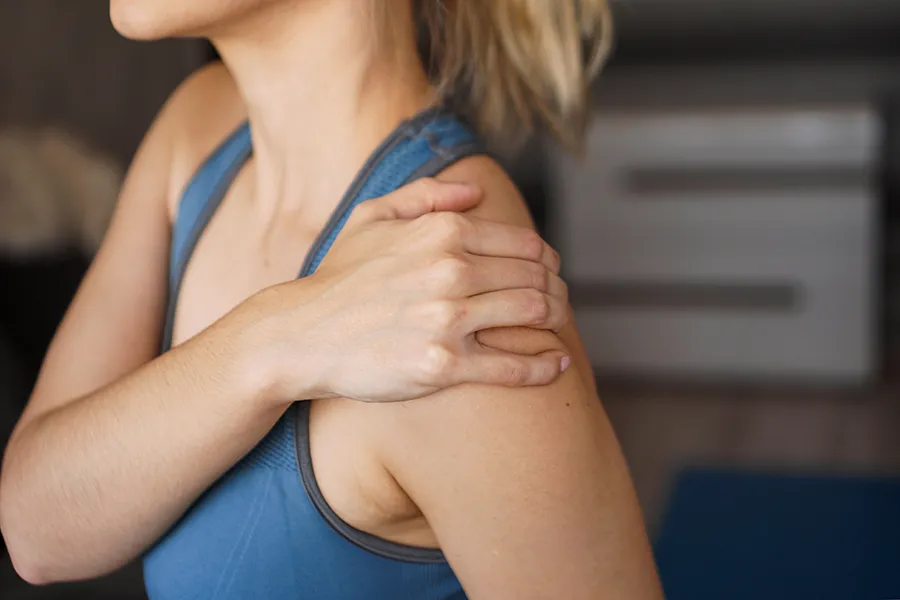 Chronic-Inflammation-Clinic A woman massages her sore shoulder. Get chronic inflammation treatment from Tasmin Cordie, D.C. of Sage Functional Medicine in Marlboro Township.