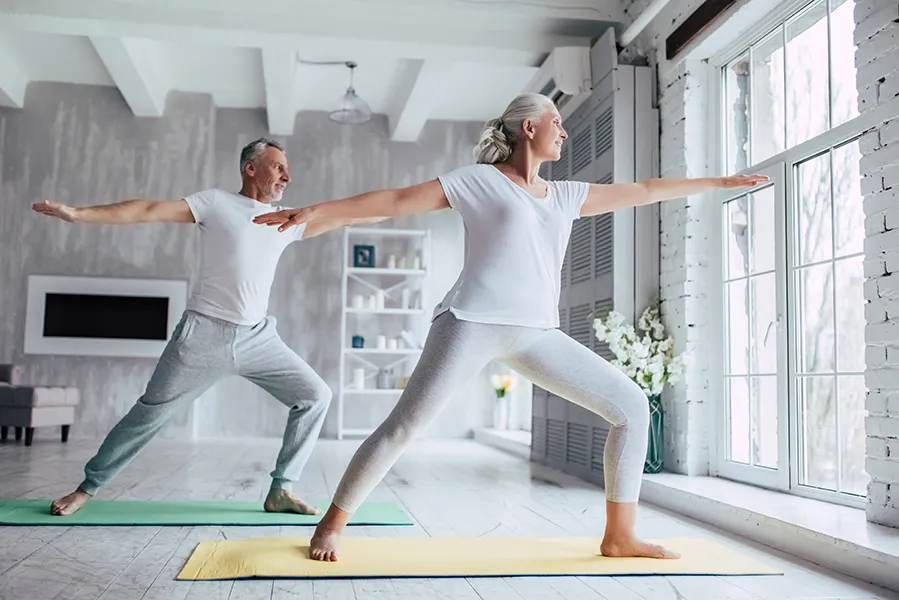 Coordination-Issues-Clinic An older couple enjoys yoga in a sunny studio. Get treatment for coordination issues from Tasmin Cordie, D.C. of Sage Functional Medicine in Marlboro Township.