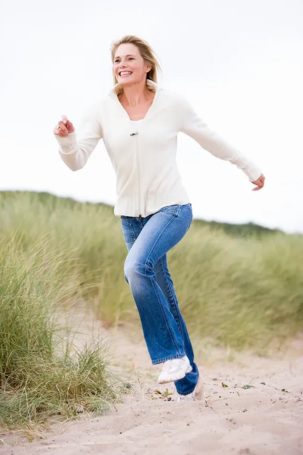 Coordination-Issues-Treatment A woman happily runs on the beach. Get treatment for coordination issues from Tasmin Cordie, D.C. of Sage Functional Medicine in Marlboro Township.
