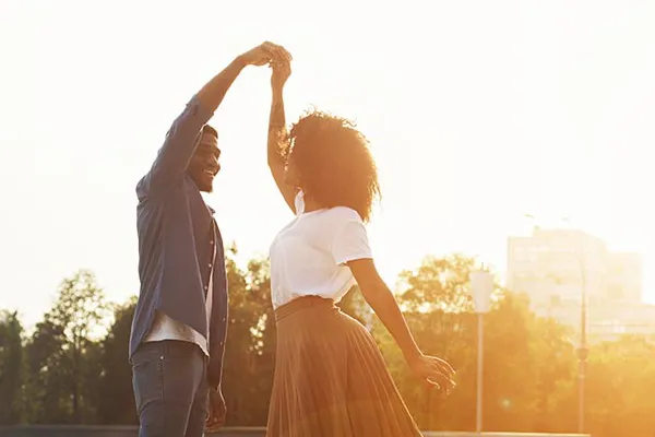 A Black couple dance outside in the sunset. Get treatment for immune support from Tasmin Cordie, D.C. of Sage Functional Medicine in Marlboro Township.
